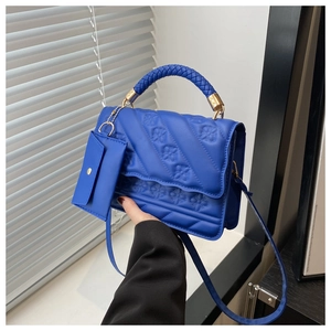 Close-up of royal blue handbag with geometric texture and matching coin purse