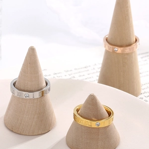 Three-color Roman numeral rings in silver, gold, and rose gold on wooden stands