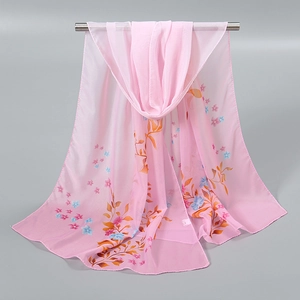 Détail d'un foulard en mousseline rose à imprimé fleuri drapé sur une barre argentée