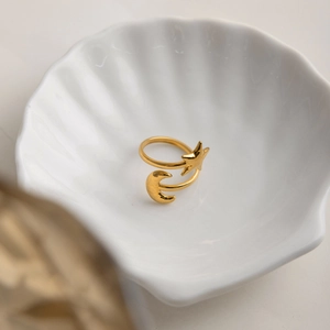 Detail of 18K gold-plated star and moon adjustable ring on a white decorative shell tray