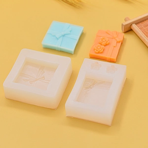 Detailed silicone mold for DIY ribbon gift box and floral soaps on warm background