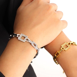 Detailed close-up of gold and silver couple link bracelets with square diamond-set charms