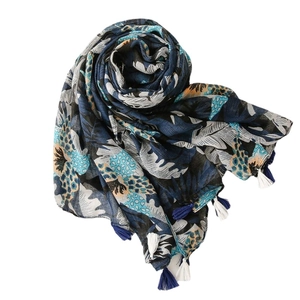 Navy blue linen-feel scarf with tropical leaf print and tassel fringe on white background