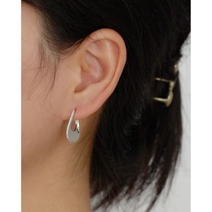 Close-up of a silver U-shaped earring with small sparkling stones on female ear