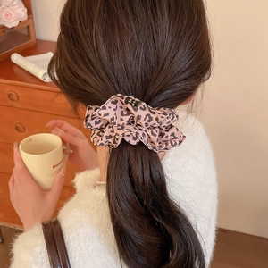 Pink leopard print satin scrunchie styled in a low ponytail for an elegant fashion look