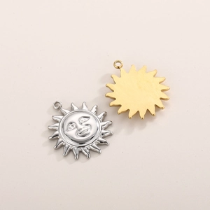 Macro shot of stainless steel sun pendants in gold and silver showing face relief and smooth back