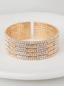 Close-up of luxury gold multi-layer cuff bracelet with sparkling clear rhinestones