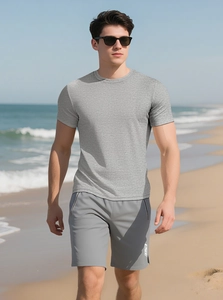 Men's grey fitness t-shirt and shorts set shown in a natural outdoor beach setting