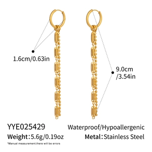 Macro detail of gold-plated geometric oval tassel earrings in stainless steel