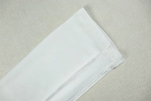 Detail of white bodysuit showing clean stitching and smooth high-quality knitted fabric