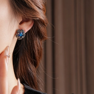 Nahaufnahme von gotischen Sternohrringen mit blauem Edelstein und schwarzen Kristallen