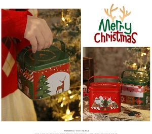 Vista dettagliata di scatole regalo di Natale in latta con manici e motivi festivi