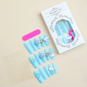 Detailed view of long blue press-on nails with 3D cloud and star charms in premium packaging