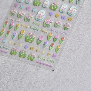 Macro shot of 3D embossed nail stickers featuring colorful tulips and butterfly patterns
