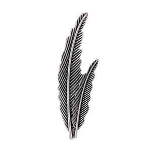 Detailed view of vintage matte silver metal brooch in a retro double feather design