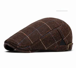 Detail of coffee plaid beret featuring classic herringbone wool and metal side buckles