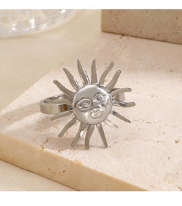 Macro side view of silver sun face ring on a beige stone base with sharp metallic details