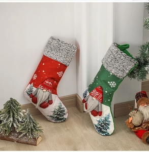 Detail of red and green fabric Christmas stockings with Santa and tree 3D ornaments