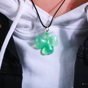 Dettaglio del ciondolo a quadrifoglio in resina verde con glitter su cordino nero