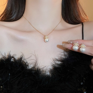 Elegant gold crown and pearl jewelry set featuring a necklace and stud earrings
