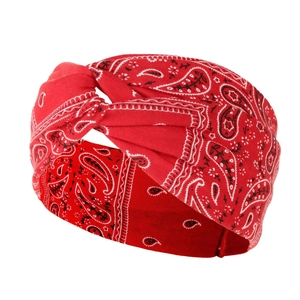 Detail of red paisley yoga headband with a twist knot design and soft cotton texture