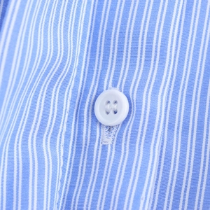Close-up of blue and white striped shirt fabric with a white round four-hole button
