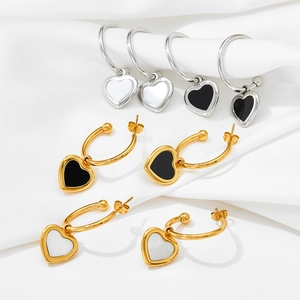 Macro detail of heart-shaped hoop earrings in gold and silver with shell inlay