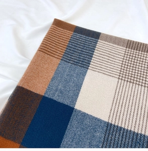 Detail shot of orange and blue plaid cashmere-like scarf with thick twill weave texture