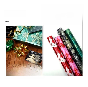 Detail of Christmas wrapping paper rolls with pink bows and green snowflake patterns