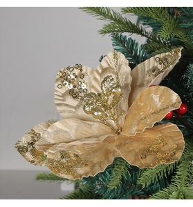 Close-up of golden sequined poinsettia flower with red berries on Christmas tree