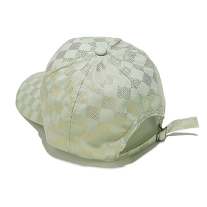 Detail view of mint green baseball cap featuring gold checkerboard pattern and metal buckle