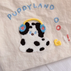 Detail of the high-density puppy chenille embroidery on a beige canvas tote bag