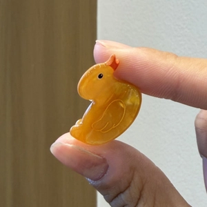 Dettaglio della pinza per capelli a forma di papera gialla traslucida con becco rosso e occhi
