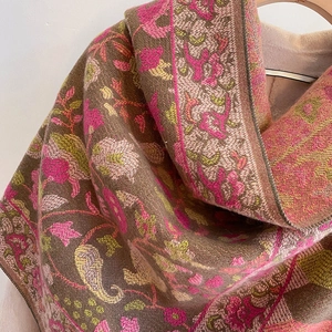 Detailed view of woven floral paisley pattern and tassel trim on warm winter shawl