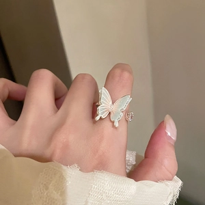 Detailed macro of a silver butterfly open ring with iridescent wings and zircon stones