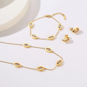 Elegant 18K gold plated jewelry set with white drop-shaped crystals on white platform