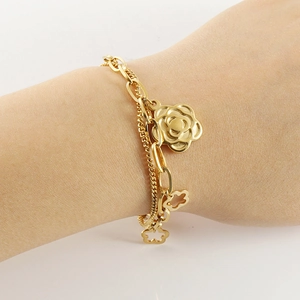 Golden double chain bracelet featuring camellia flower charms on a woman's wrist