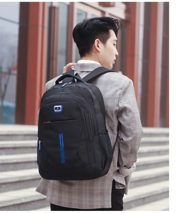 Male model carrying a black waterproof sport backpack with multiple storage pockets