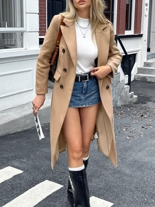 Detail of camel double-breasted trench coat with long sleeves and stylish urban collar