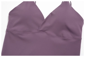 Detail of dark purple yoga top featuring deep V-neckline and wavy stitching design