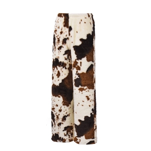 Détail du motif imprimé vache sur ce pantalon ample en polaire douce pour l'hiver