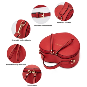 Detail view of red heart bag showing adjustable straps, metal zippers, and reinforced handles