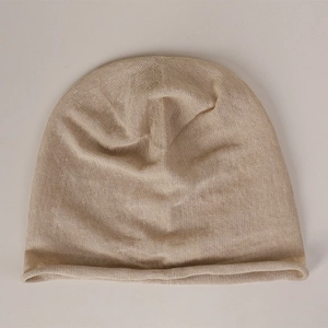 Detail shot of beige 100% linen knit beanie showing fine mesh texture and rolled edge