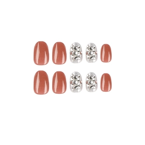 Press-on nails in brick red and silver glitter with rhinestones on white background