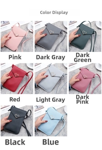 Touchscreen phone crossbody bag in eight colors with heart buckle shown on textured desk