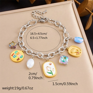 Golden stainless steel charm bracelet with stars, tulips and roses on a jewelry tray