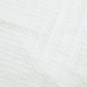 Macro shot of white textured seersucker fabric detailing the ruffled pleats on this dress