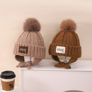 Cozy winter knit earmuff hat with pompom and patch for boys and girls in brown tones