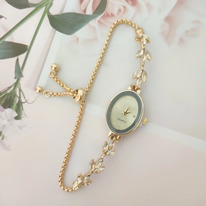 Detail of adjustable gold wheat leaf bracelet watch with diamond accents and pull clasp