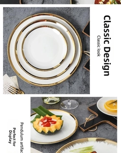 Detail of white ceramic plates with gold rim stacked on grey stone background